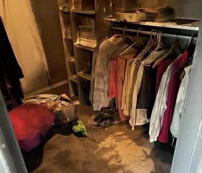 Walk-In Closet affected by smoke damage. Excessive soot on clothing and all surfaces of the closet