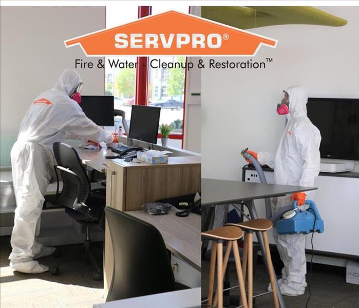 Tech spraying SERVPRO disinfectant and wiping high touch-points