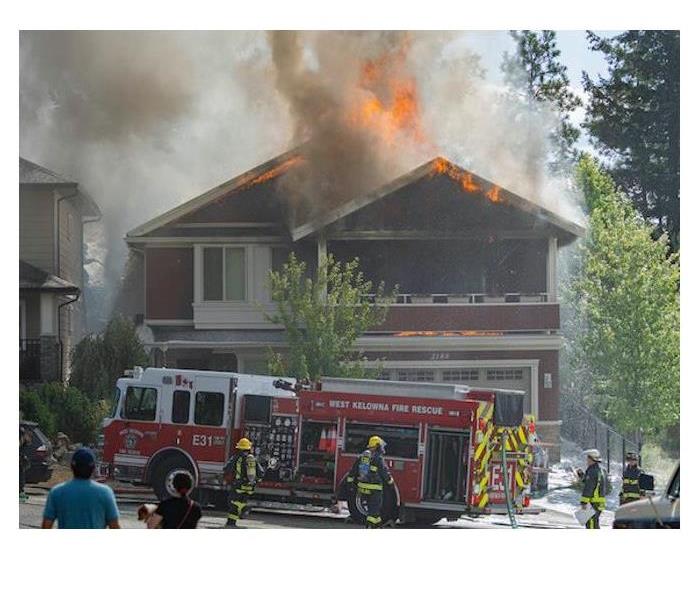 Fire fighters extinguishing a house fire in West Kelowna, BC
